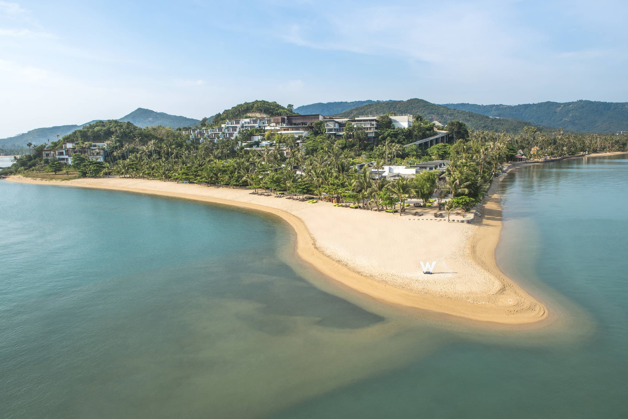 Iconic circular sunken seating at W Koh Samui's Woo Bar floating in an infinity pond at sunset.