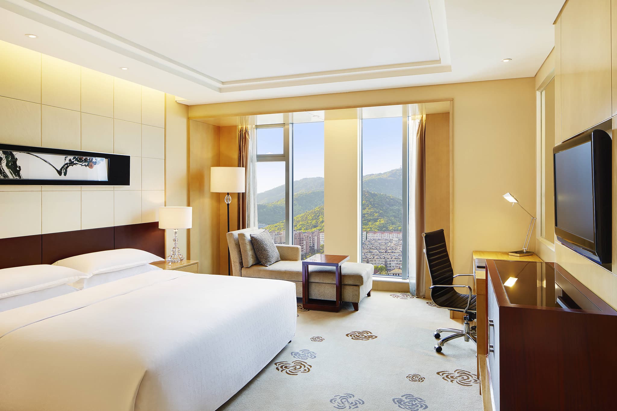 A guest room window nook at Sheraton Wuxi Binhu Hotel framing a dramatic view of Mount Xihui and the distant pagoda.