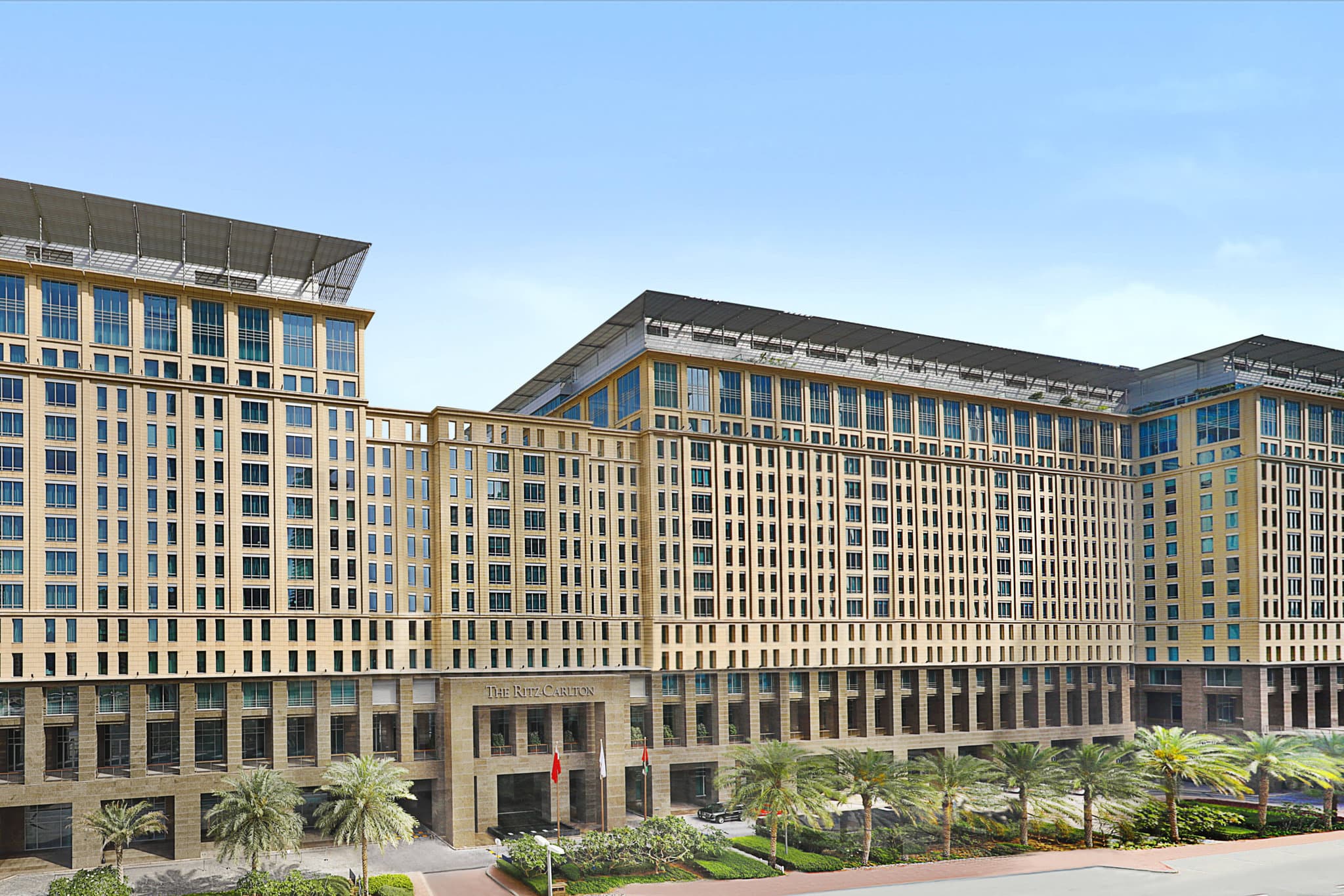 The Ritz-Carlton DIFC's 10-story waterfall feature illuminated at night, contrasting with the limestone facade.
