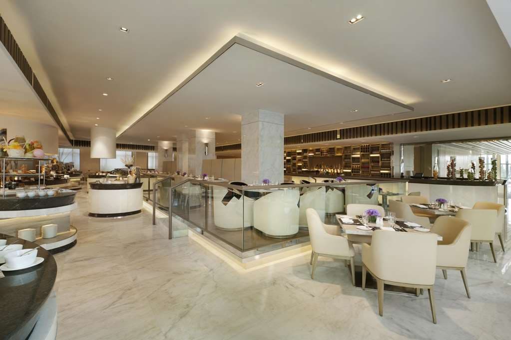 Hilton Xi'an High-tech Zone indoor pool area featuring teal tiling, lounge chairs, and soft ambient lighting.