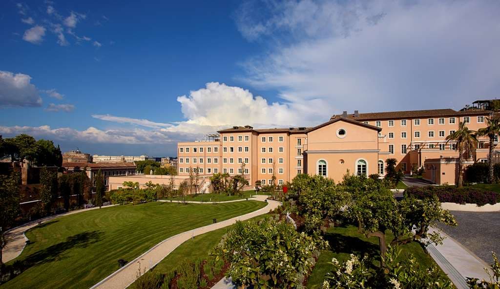 흰색 카바나와 무성한 지중해 정원으로 둘러싸인 Villa Agrippina Gran Meliá의 매력적인 1920년대 스타일 야외 수영장.