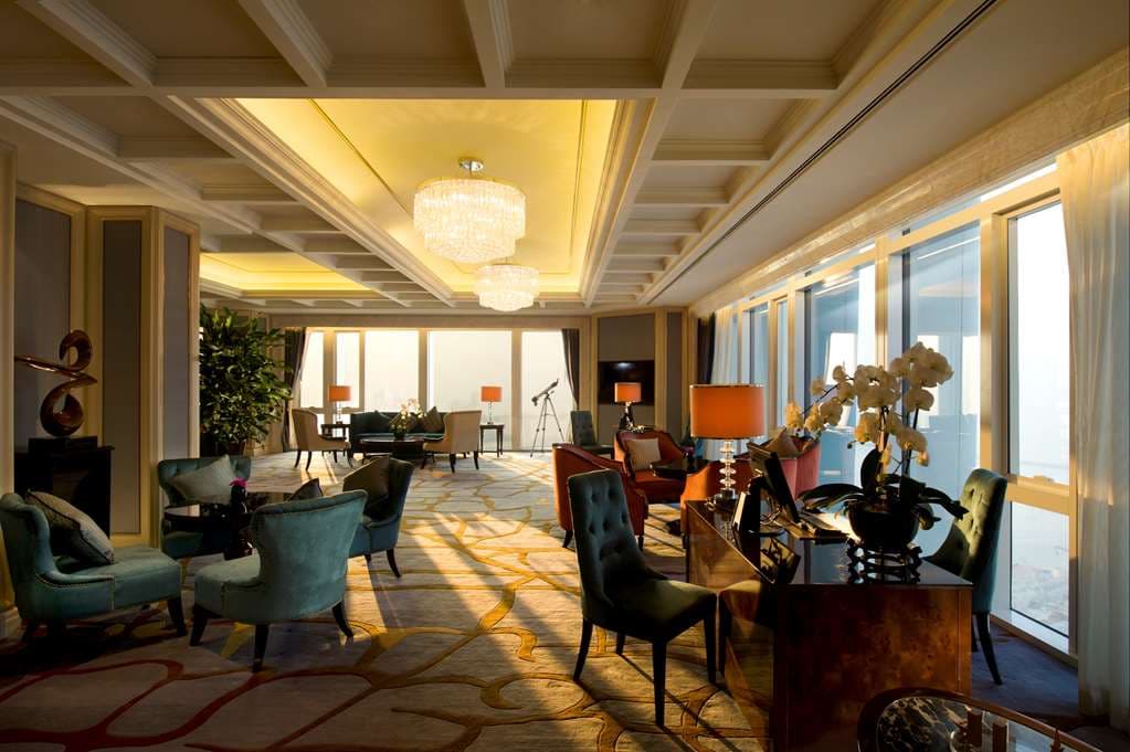 The Conrad Dalian's indoor pool featuring a high cathedral-style ceiling and ambient lighting.