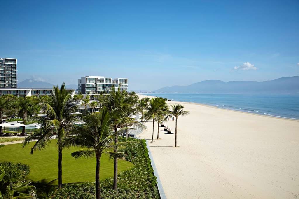 Aerial view of Hyatt Regency Danang's labyrinthine pool complex bordering the white sands of Non Nuoc Beach.