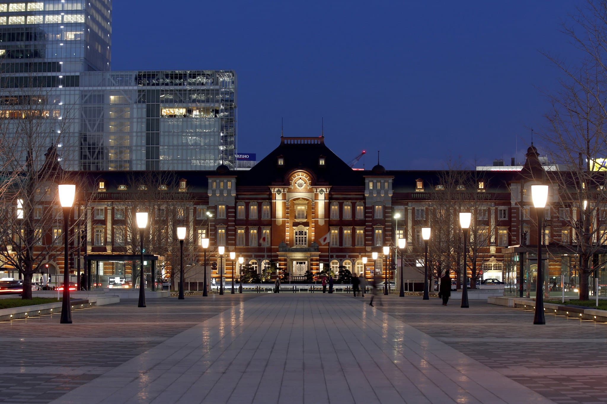 The Tokyo Station Hotel's grand Atrium breakfast lounge featuring a high skylight ceiling and exposed historic red brick walls.