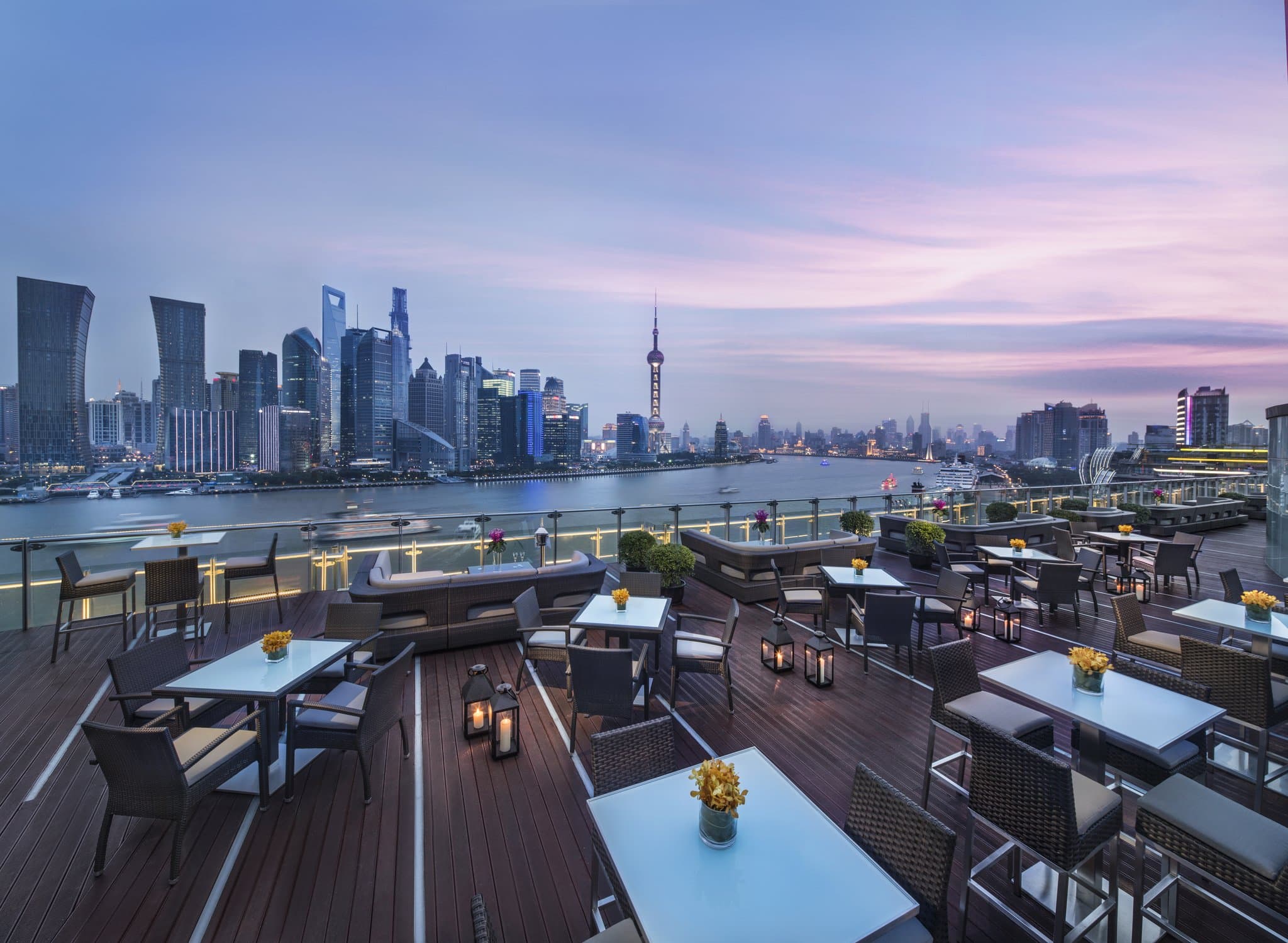 A woman in a silk robe gazing at the Shanghai skyline from an in-room private dipping pool at Banyan Tree Shanghai.