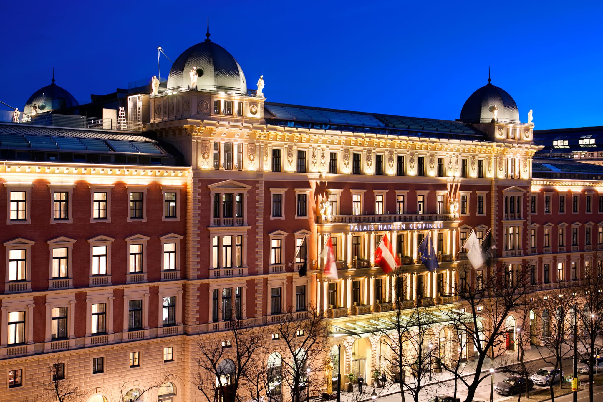 Lobby lounge of Anantara Palais Hansen Vienna featuring massive marble columns, contemporary lighting, and guests enjoying afternoon tea.