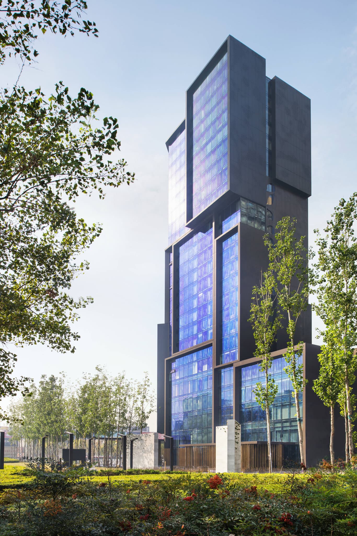 Low-angle shot of the cavernous Le Méridien Zhengzhou atrium featuring bronze poles and stacked skylights designed by Neri&Hu.