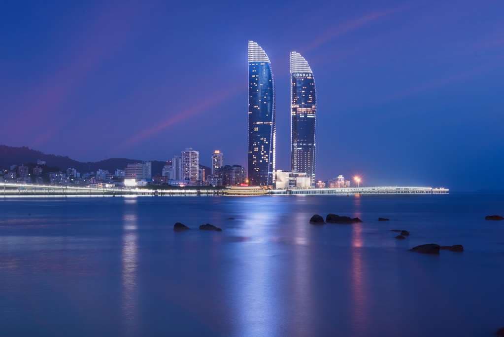 View from Conrad Xiamen room featuring floor-to-ceiling windows overlooking the sea and Gulangyu Island.