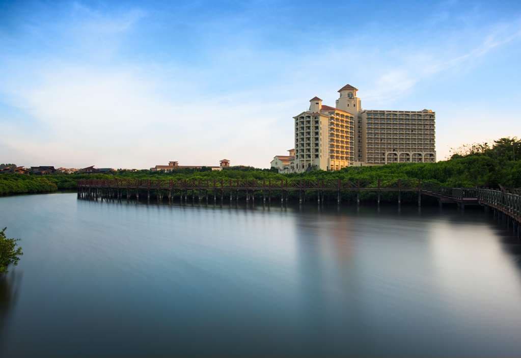 Aerial view of DoubleTree Chengmai's lagoon pool surrounded by Spanish-style buildings and mangrove wetlands.