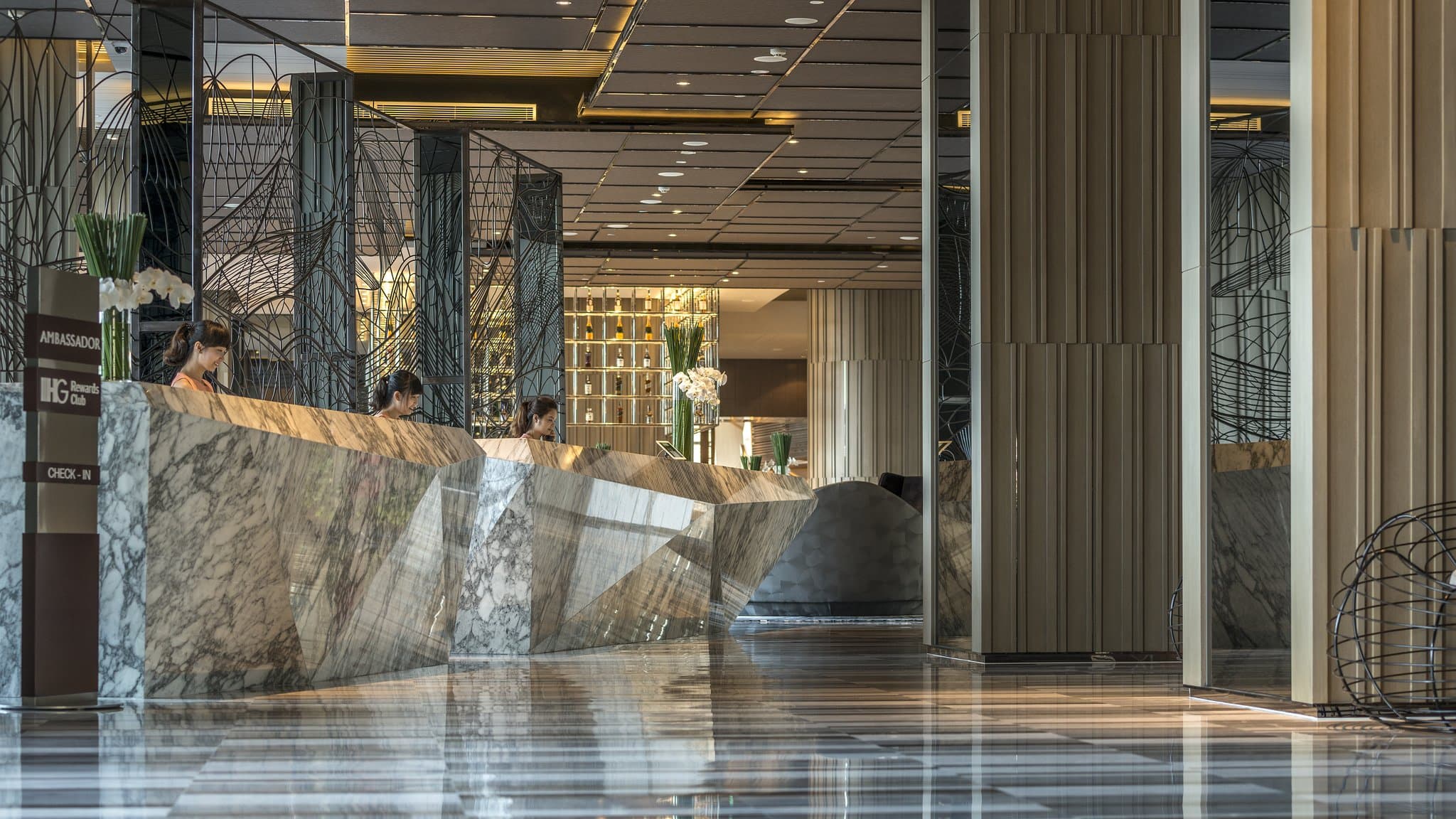 A panoramic view of the InterContinental Nha Trang pool deck at twilight, featuring illuminated jacuzzi beds and the curved hotel facade against a deep blue coastal sky.