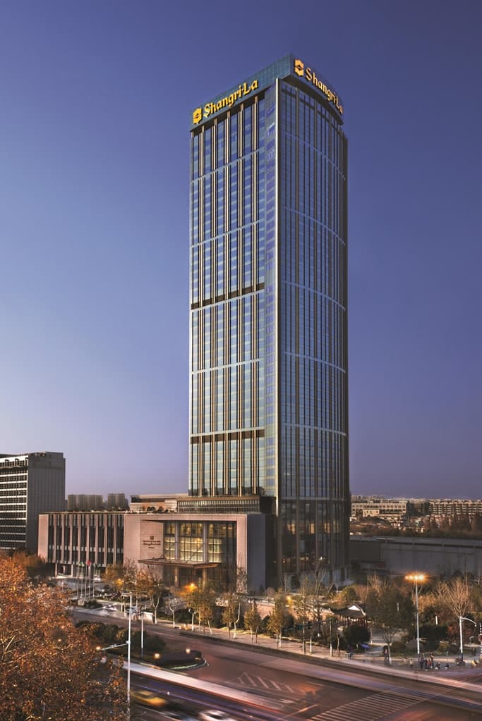 南京香格里拉酒店高层套房内景,透过落地窗可俯瞰玄武湖全景及远处的紫金山脉。