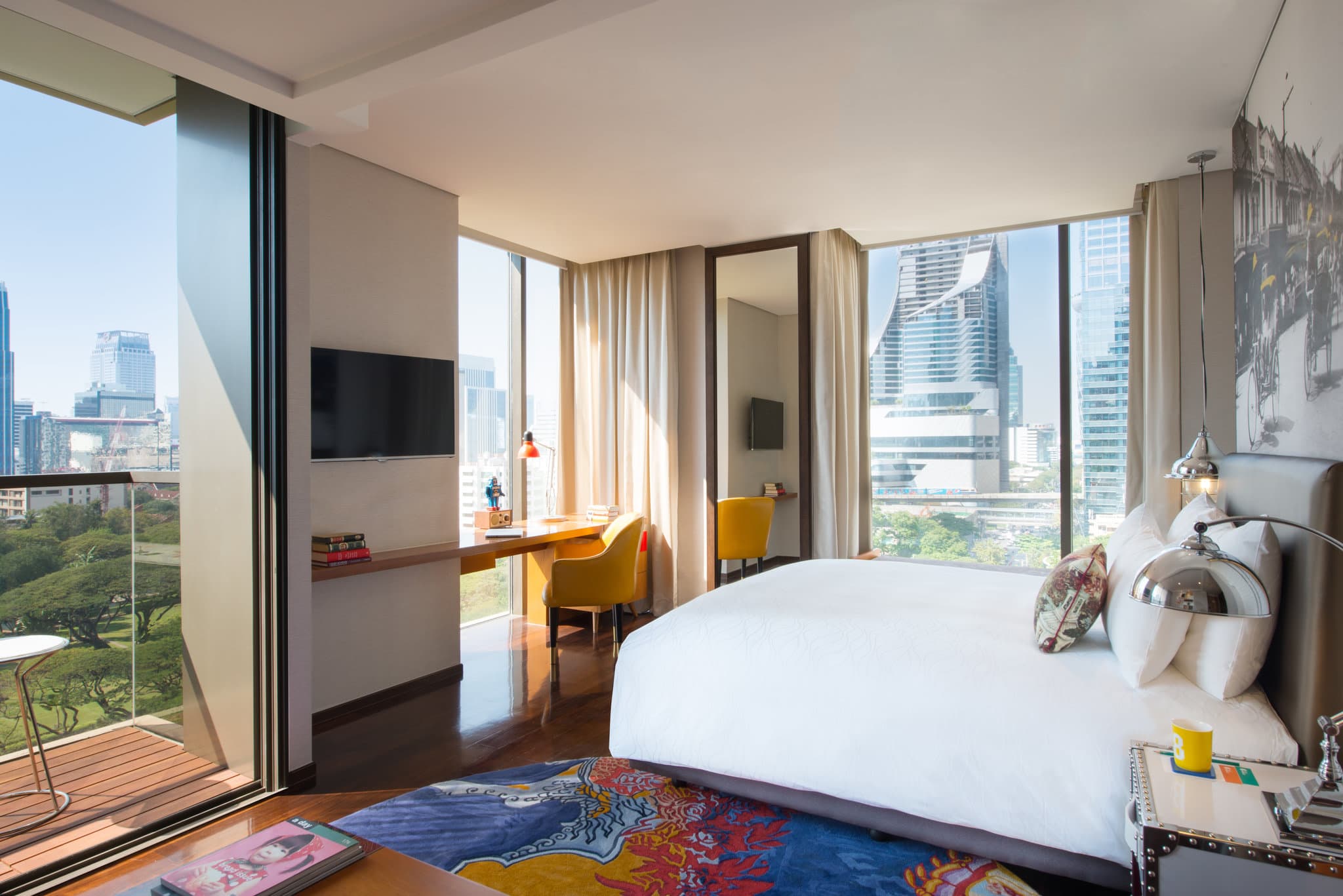 A dramatic dusk view of Hotel Indigo Bangkok's 24th-floor infinity pool overlooking the illuminated city skyline.