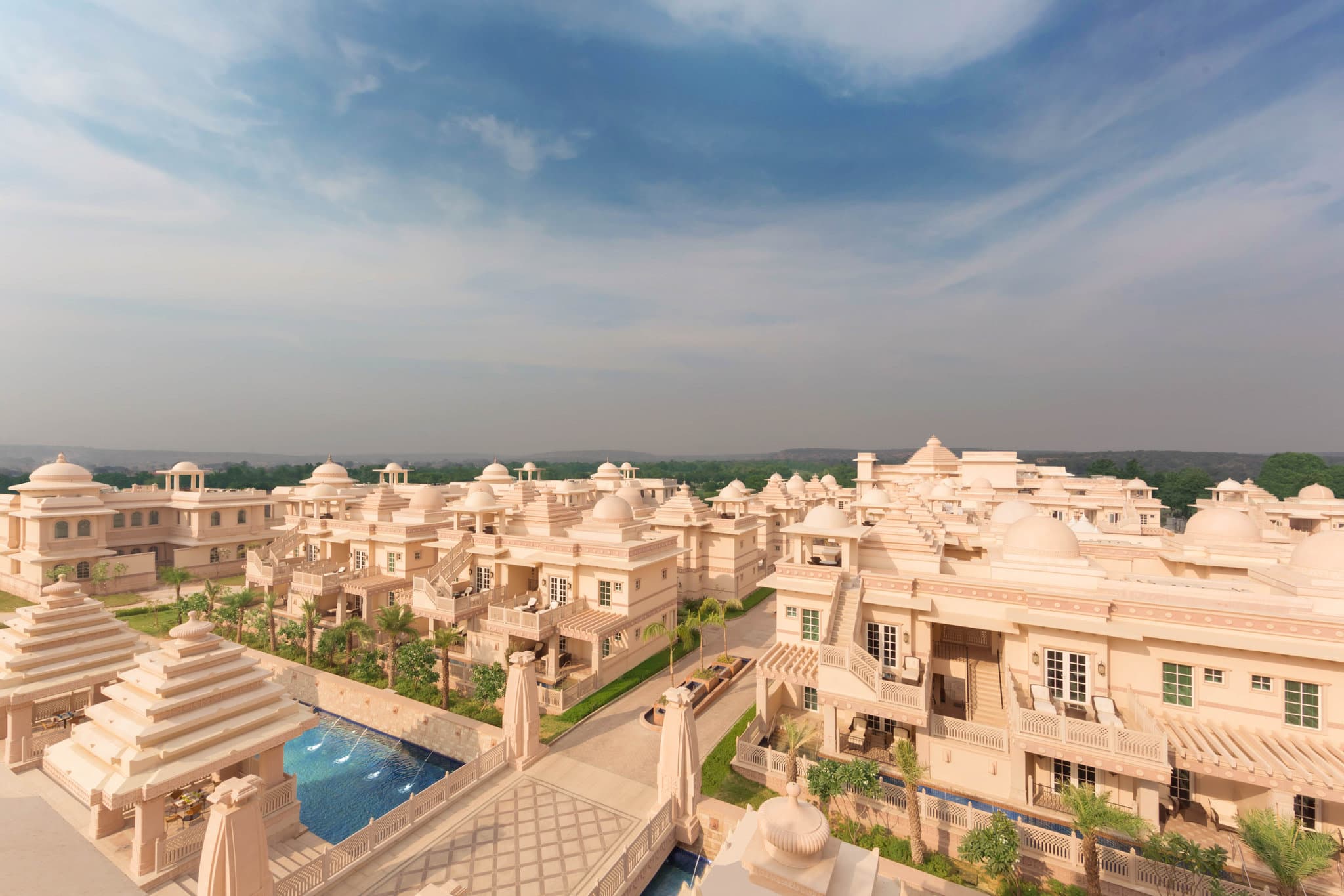 Sunset view of ITC Grand Bharat's domed architecture reflecting in the Yamuna-inspired water bodies.