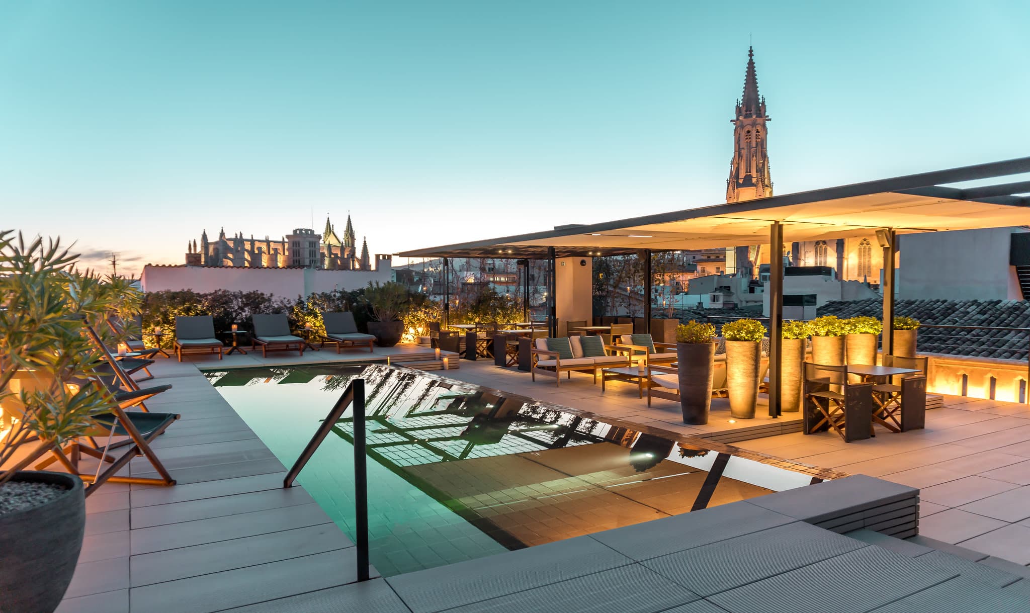 해 질 녘 Sant Francesc Hotel Singular의 루프탑 수영장과 배경으로 보이는 산트 프란세스크 성당.