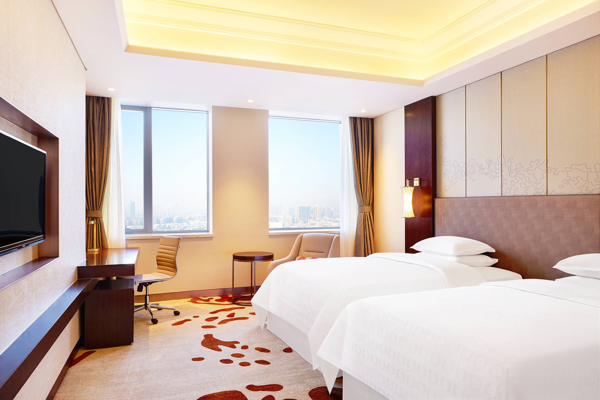 The cavernous, marble-clad lobby of Sheraton Harbin Xiangfang featuring high ceilings and modern chandeliers that echo Russian Baroque geometry.