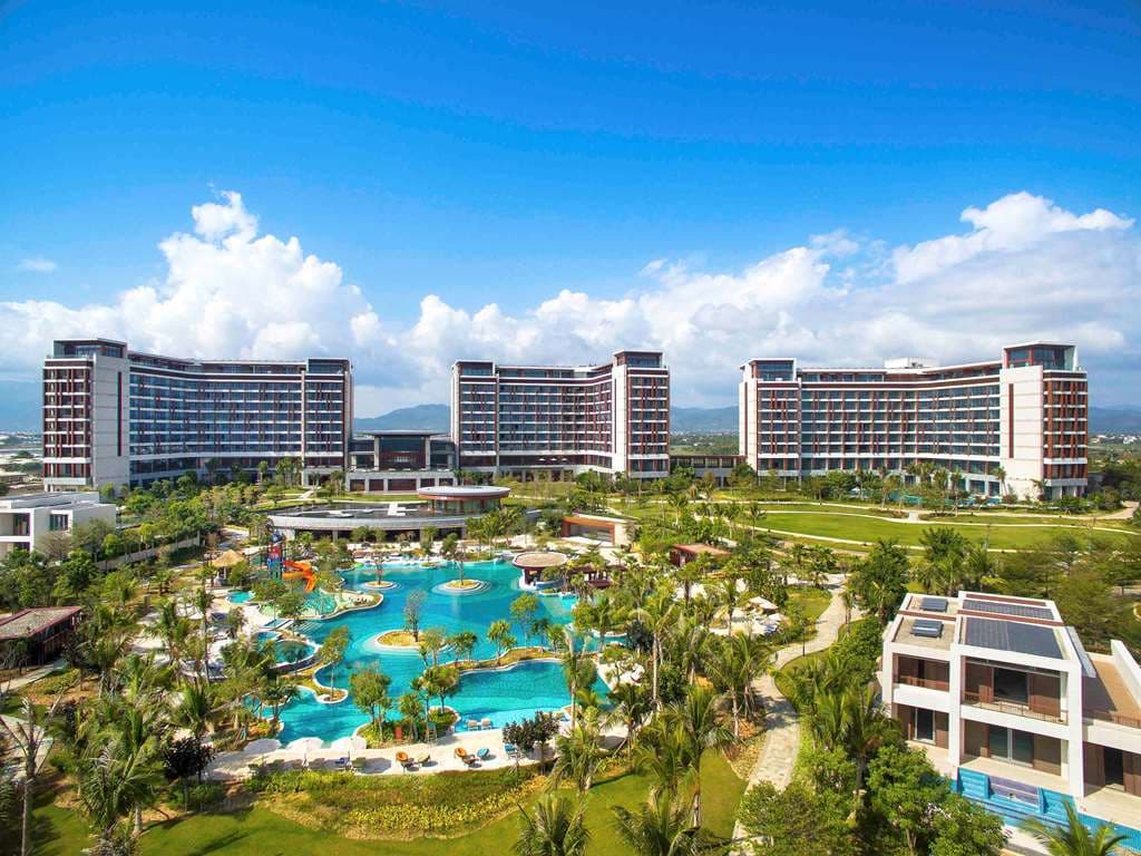 Symmetrical view of the Sofitel Sanya Leeman Resort lobby framing the lagoon pool and ocean beyond.