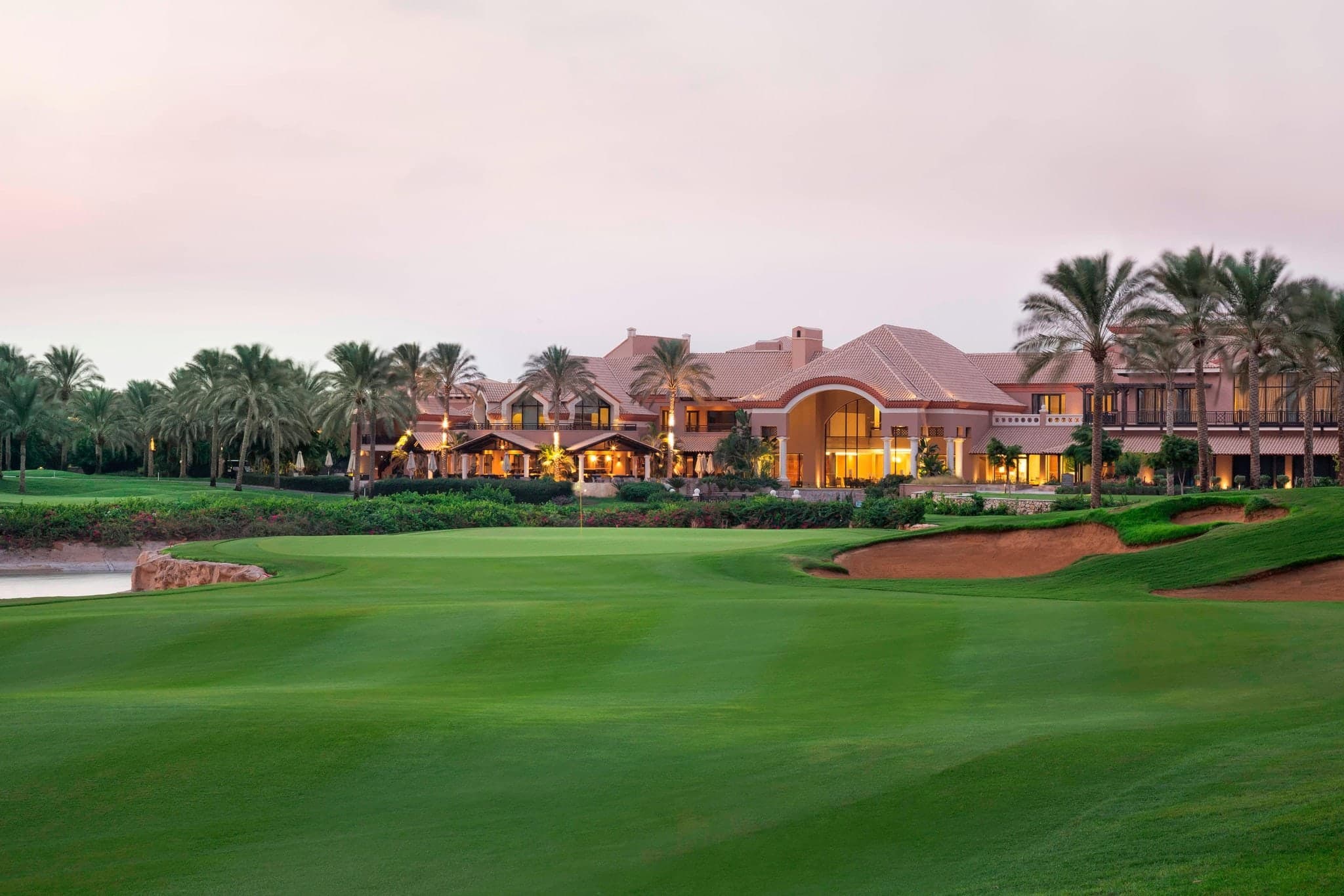 The Westin Cairo Golf Resort & Spa outdoor lagoon pool surrounded by palm trees and white lounge chairs.