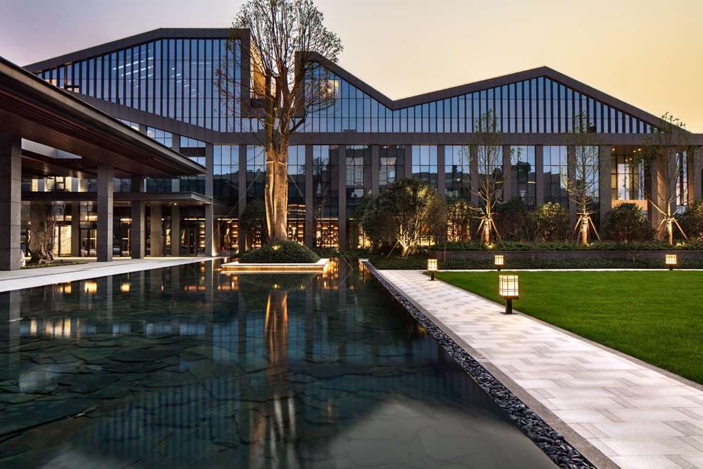 A misty view of Dongqian Lake from the terrace of Hilton Ningbo, featuring a modern infinity pool blending into the natural lake horizon.
