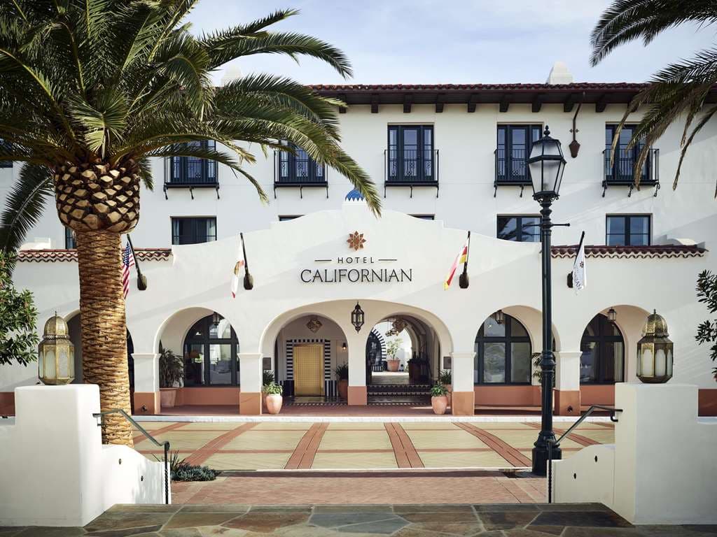 산타 이네즈 산맥과 태평양의 전경이 보이는 Hotel Californian의 Tan-Tan 루프탑 수영장 데크와 흰색 라운지 체어.