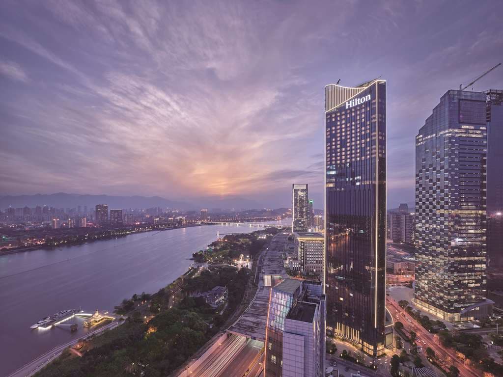Hilton Fuzhou 41st floor indoor infinity pool with panoramic floor-to-ceiling windows overlooking the Min River and city skyline.