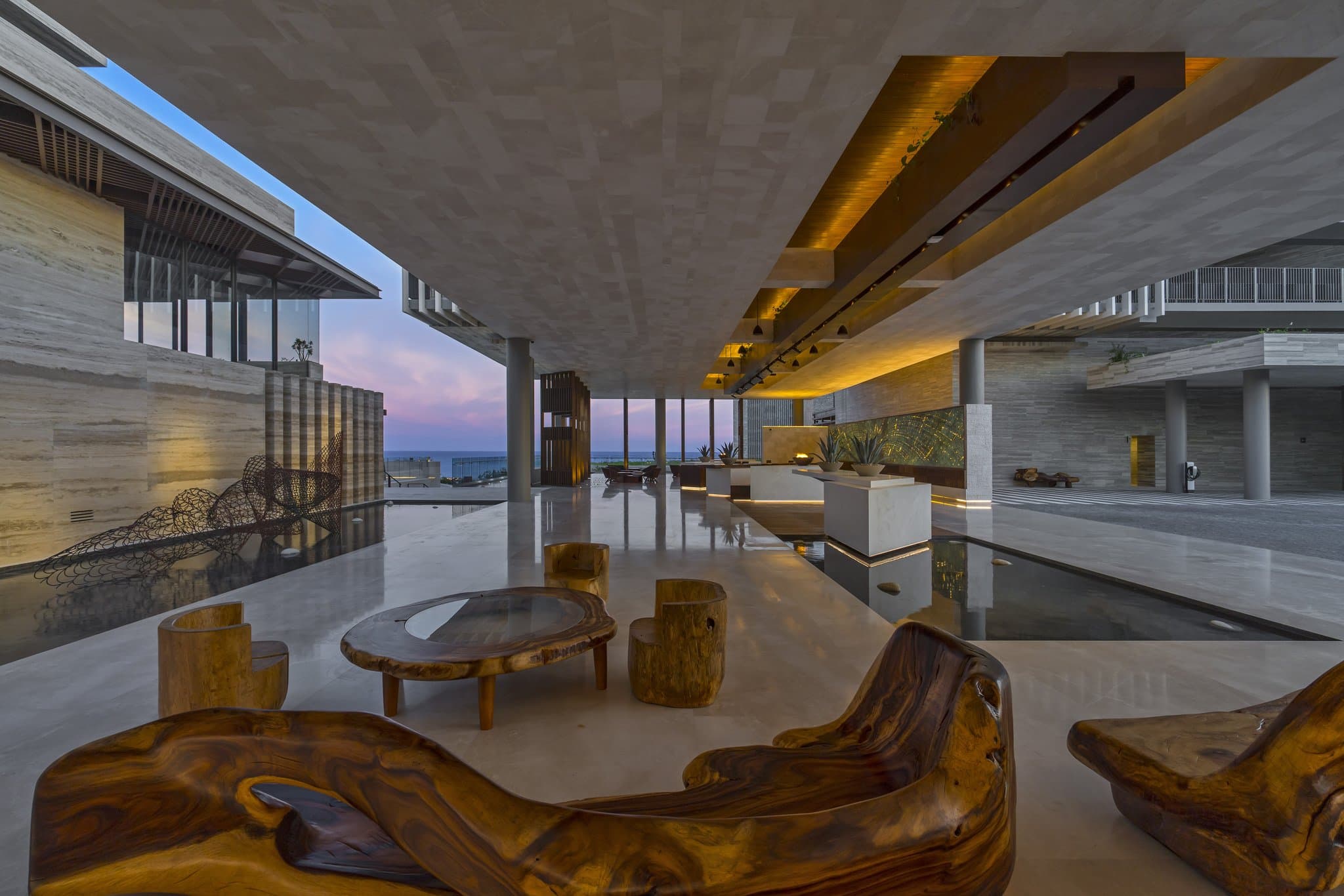 Solaz resort infinity pool lined with green granite merging with the Sea of Cortez, framed by modern concrete architecture.