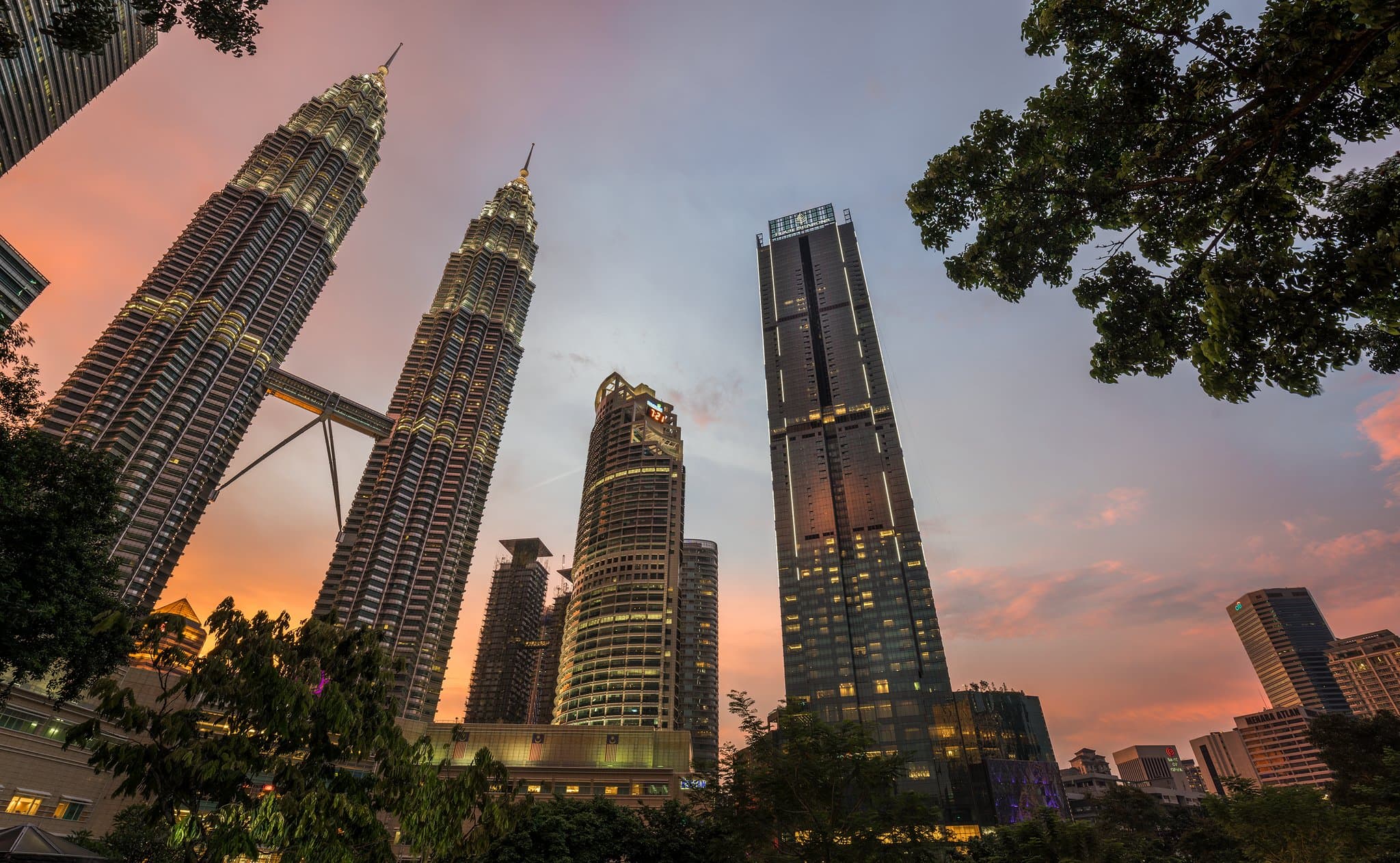 View of the Petronas Twin Towers seen through the floor-to-ceiling windows of a Four Seasons Kuala Lumpur guest room.