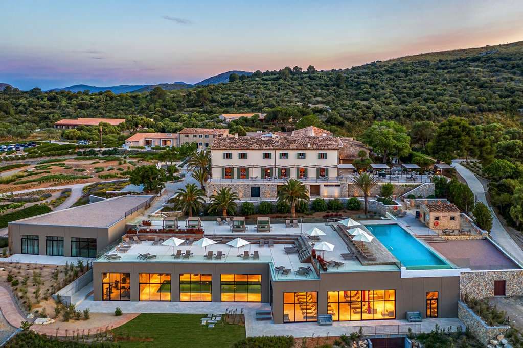 A panoramic view of the 20m infinity pool at Carrossa Hotel Spa Villas with the Bay of Alcúdia and Llevant mountains in the background.