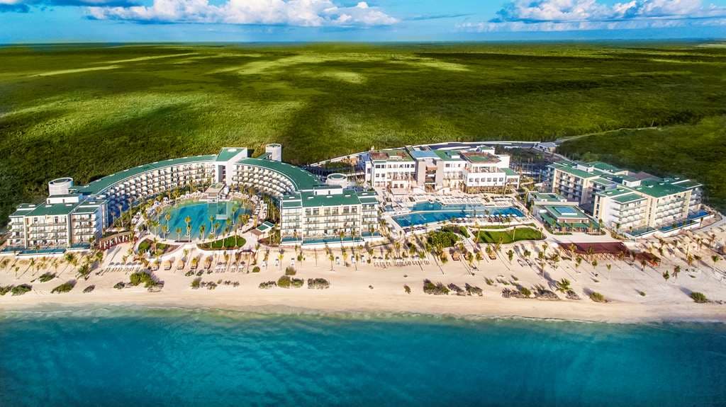 Aerial view of Haven Riviera Cancun's circular zero-entry pool and Serenity Club swim-out suites facing the Caribbean Sea.