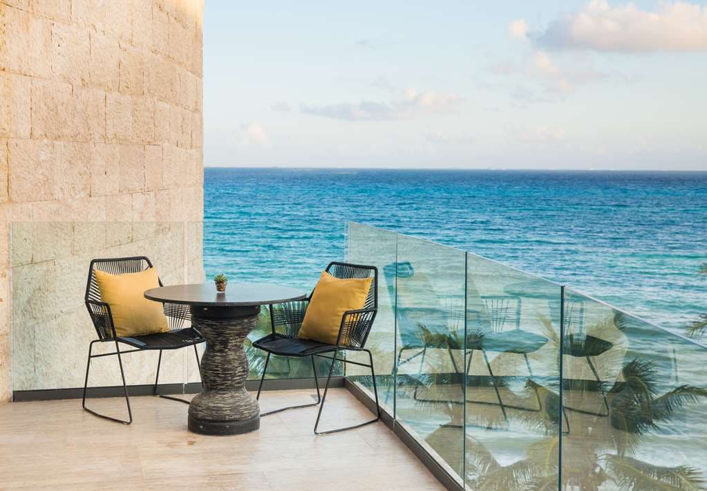 Hyatt Centric Beach House oceanfront pool deck at golden hour with wood-slatted pergolas and Caribbean Sea views.