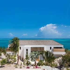 A private infinity pool at Beach Enclave North Shore overlooking the turquoise ocean from a limestone cliff edge.