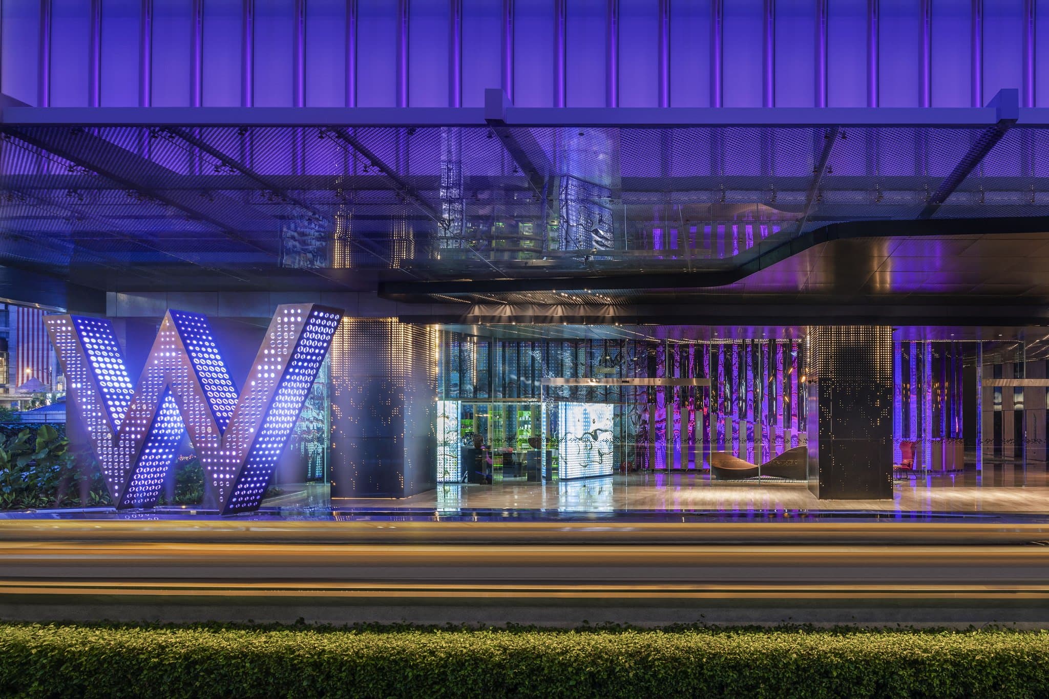 W Kuala Lumpur WET Deck infinity pool at night with illuminated Petronas Twin Towers in the immediate background and neon purple lighting.