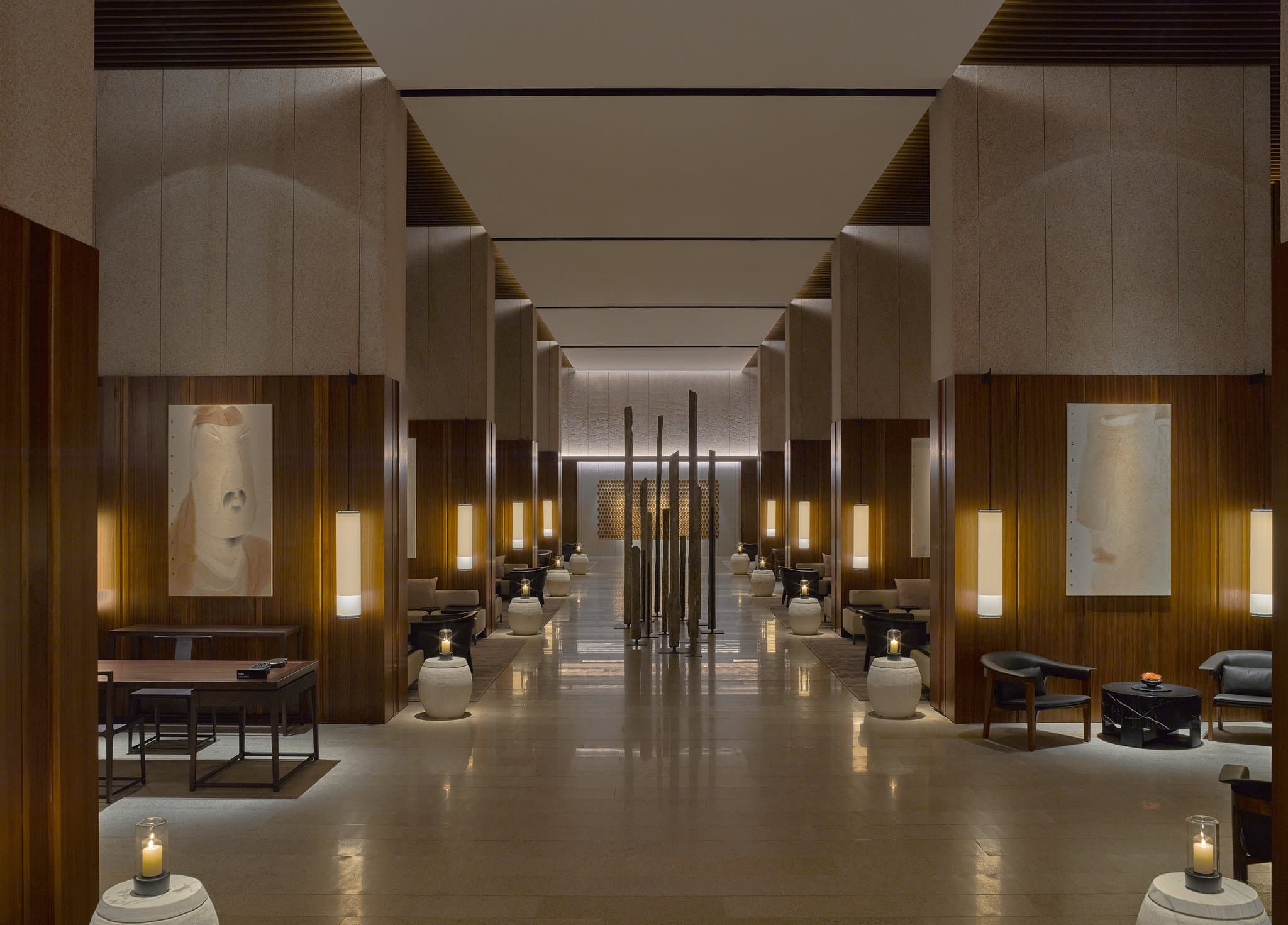 Symmetrical view of Lohkah Hotel & Spa's lobby colonnade leading to a white sculptural spiral staircase, reflecting a minimalist Zen aesthetic.