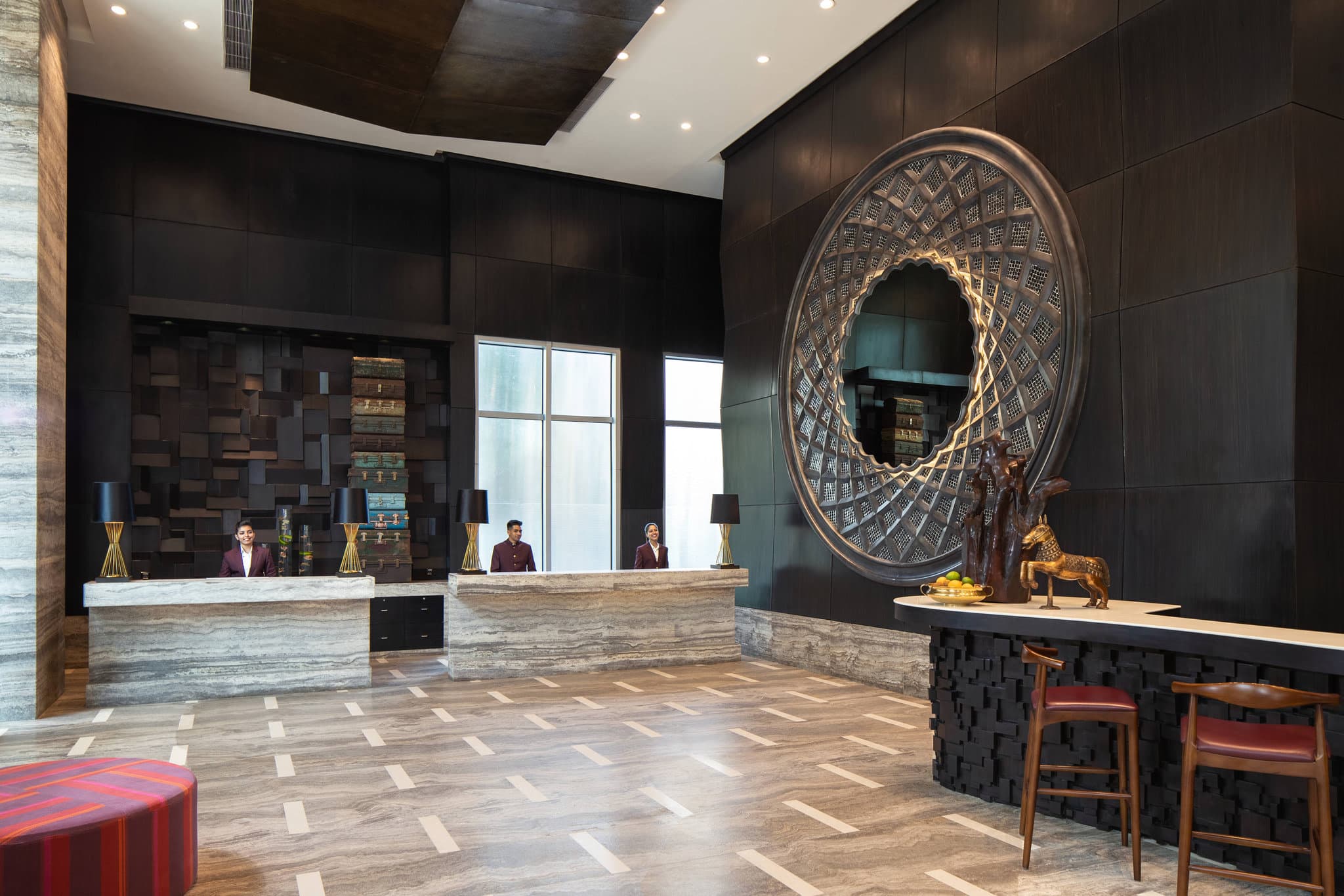 A stylized hotel bar with a ceiling structure resembling a polo helmet, overlooking a green racecourse.