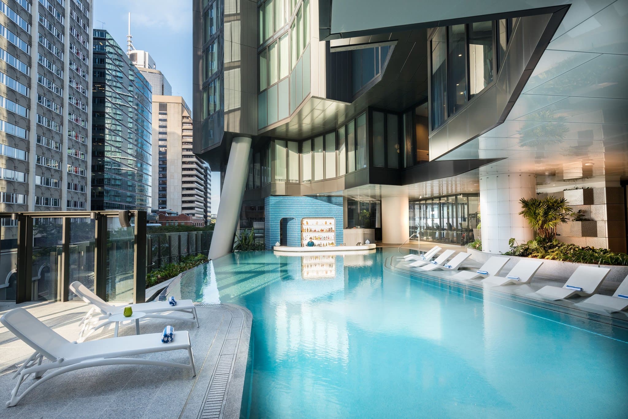 Swim-up bar at The Westin Brisbane's Nautilus pool deck surrounded by tropical landscaping.