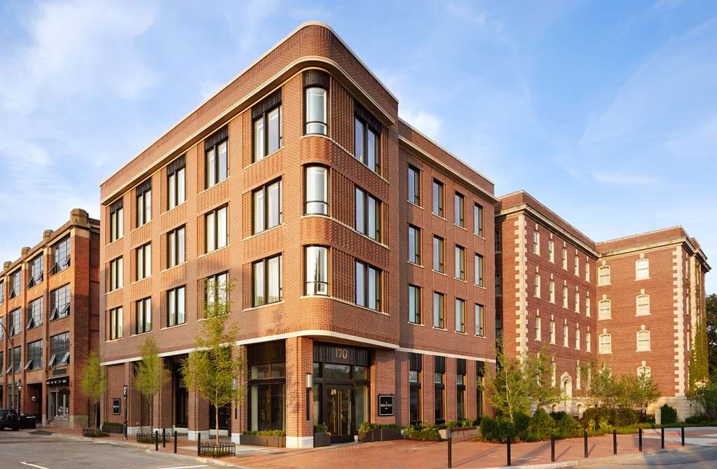 The Whitney Hotel Boston exterior showing classic brick architecture and the Peregrine restaurant entrance on a sunny Beacon Hill day.
