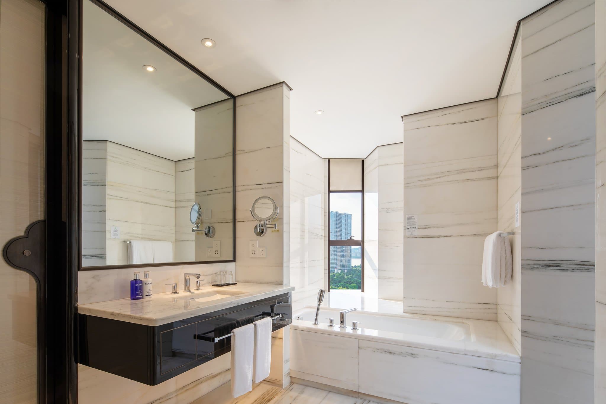 Spacious modern guest room at Voco Hangzhou Binjiang Minghao with city-view windows and contemporary decor