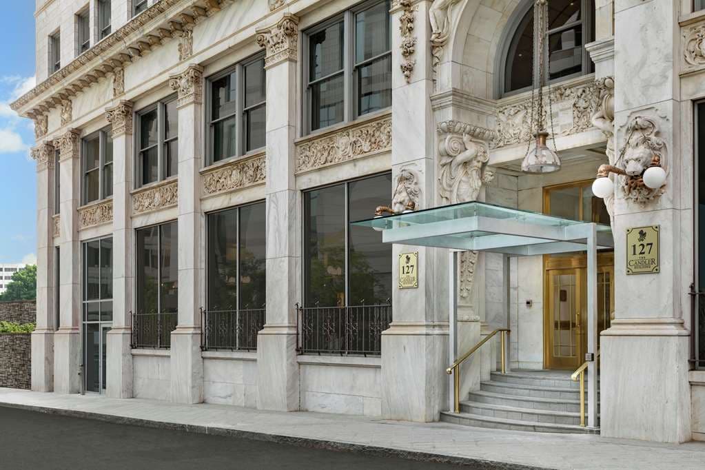 The Candler Hotel lobby featuring grand marble columns, a crystal chandelier, and the historic Beaux-Arts staircase.