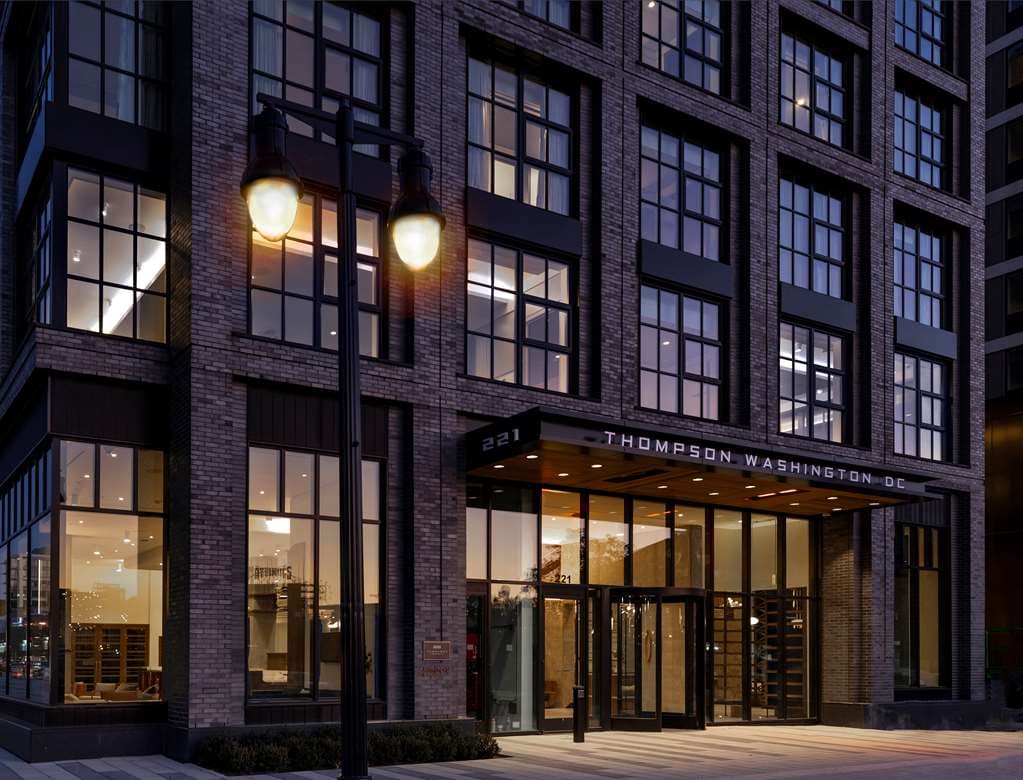 Thompson Washington D.C. facade featuring industrial-chic floor-to-ceiling windows and the rooftop terrace of Anchovy Social at twilight.