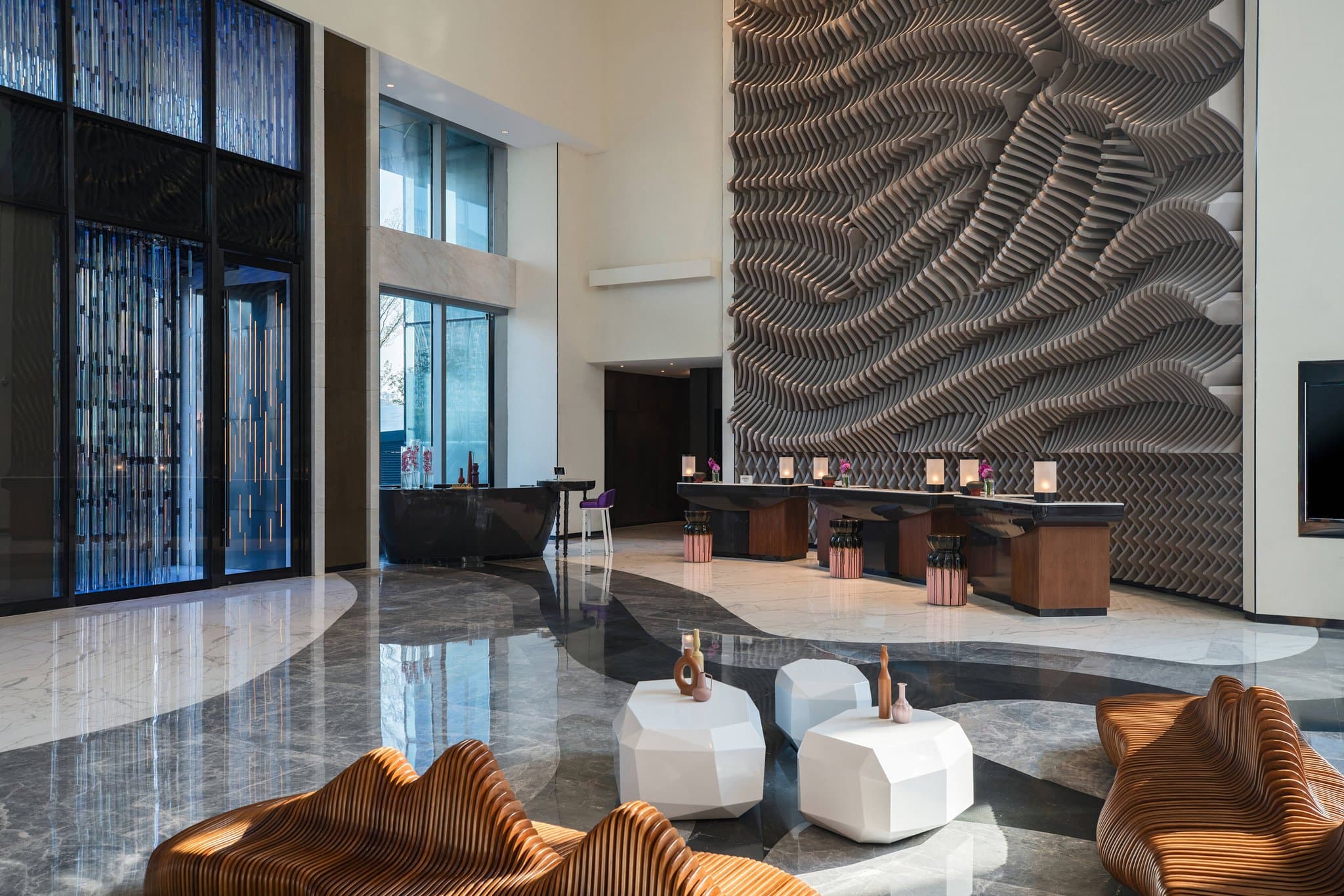 Dramatic lobby interior of Renaissance Nanning featuring vertical glass rods resembling rain and a modern terrace sculpture.