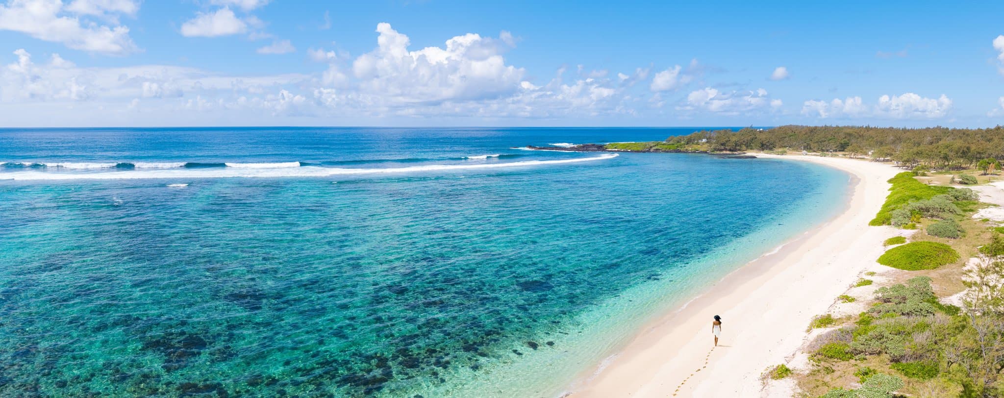 Anantara Iko Mauritius 30-meter ozone infinity pool overlooking Le Chaland Beach with modern basalt stone architecture in the background.
