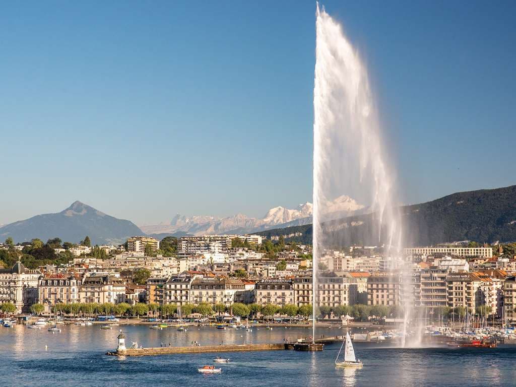 View of the Jet d'Eau fountain from a Fairmont Grand Hotel Geneva balcony, with the lake glistening in the background.