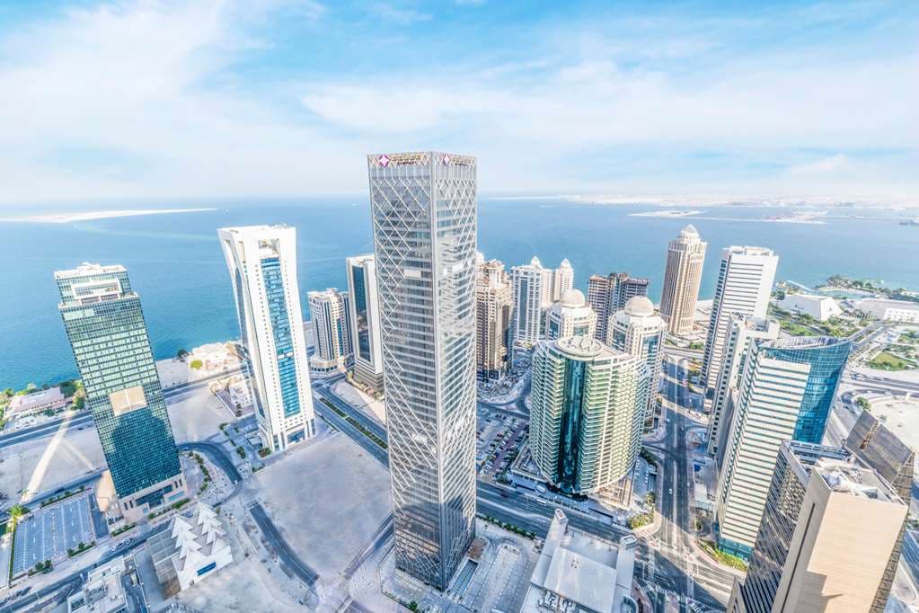 A swimmer looking out at the Doha skyline from the 52nd-floor indoor pool at Aleph Doha Residences.