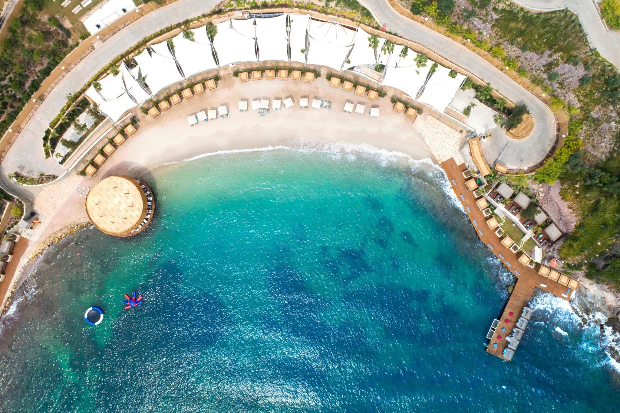 View from a suite at Le Méridien Bodrum showing a private infinity pool merging with the Aegean Sea at sunset.