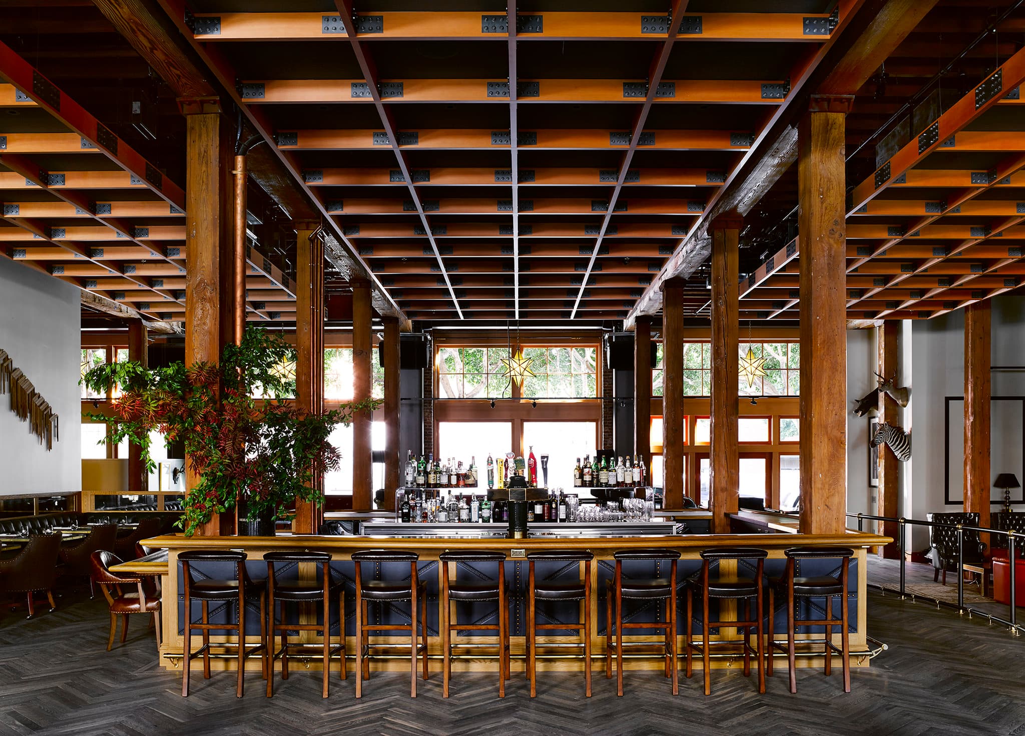 The Battery San Francisco Garden Bar featuring black and white tiled floors, industrial steel columns, and lush greenery.