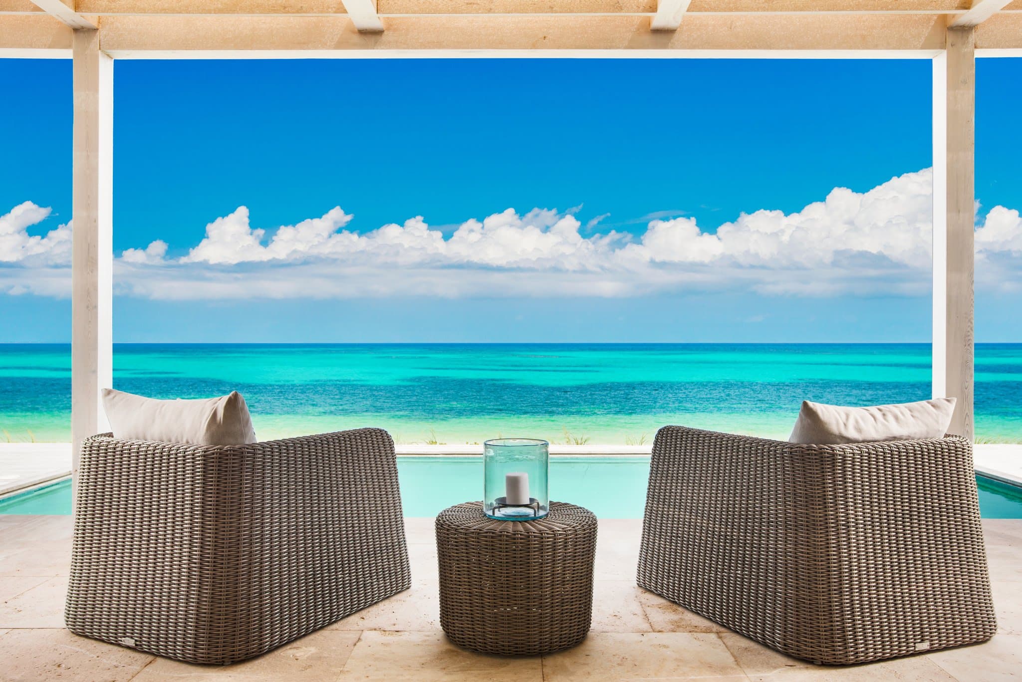 A vast infinity pool at Sailrock South Caicos blending seamlessly into the turquoise Atlantic Ocean at sunset.
